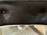 a black leather chair with buttons on the back of it