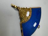 an image of a blue and gold fan shaped object on a white surface