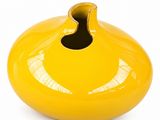 a yellow vase with a hole in the middle of it