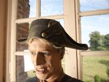 a statue of a man wearing a pirate hat in front of a window