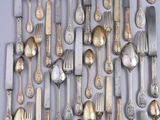 a lot of silver spoons and forks on the table