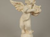 statue of an angel holding a trumpet on top of a ball