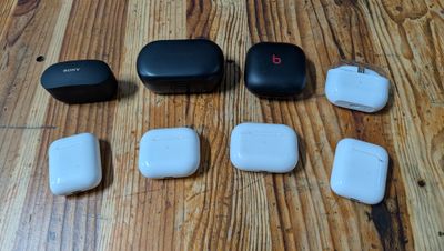 four airpods sitting next to each other on a wooden table