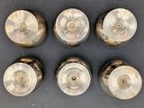 six antique brass door knobs on a black surface