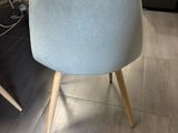 a blue chair that is sitting in front of a table