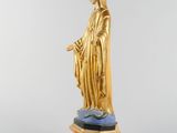 a gold statue of the virgin mary on a marble base
