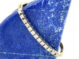 une image représentant une pierre bleue sur laquelle repose une bague en diamant