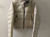a white jacket hanging on a wall next to a coat rack