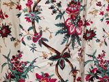 un gros plan sur une robe à fleurs ornée d'un oiseau