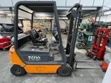 a forklift in a warehouse with other equipment in the background