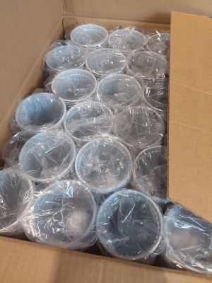 une boîte remplie de gobelets en plastique posée par terre