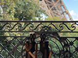view of the eiffel tower from a balcony with a pair of binoculars
