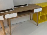 a desk with two computers on it and a yellow shelf