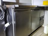 une grande cuisine en inox avec beaucoup de plans de travail