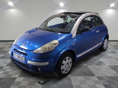 La petite voiture bleue est garée dans le garage, sur le sol à carreaux.
