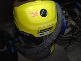 a yellow blower sitting in a garage next to a pile of tools