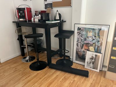 une petite table avec deux tabourets dans un coin de la pièce