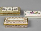 three small boxes with floral designs on them sitting on a table
