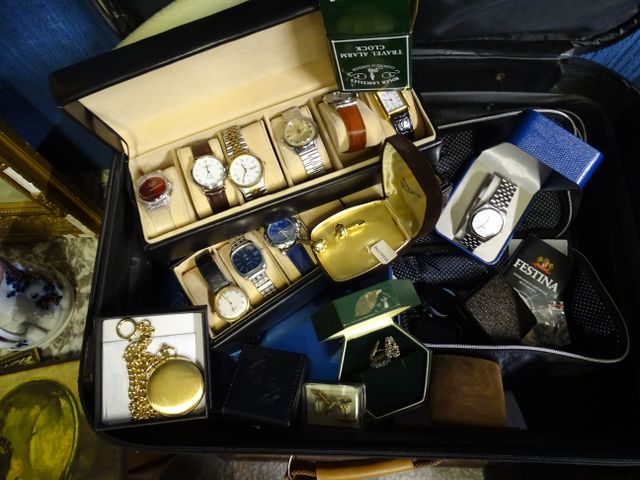 Valise garnie de montres, boutons de manchette et divers