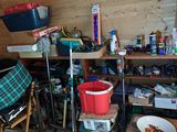 a small room with a lot of clutter and items on the shelves