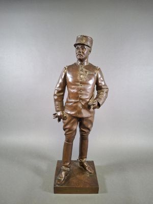 bronze statue of a man in uniform standing on a wooden base