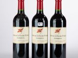 trois bouteilles de vin rouge posées côte à côte sur une table