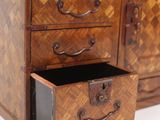a small wooden chest of drawers with a drawer underneath it
