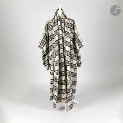 une photo d'un manteau à carreaux noir et blanc posé sur un mannequin