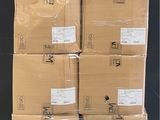boxes stacked on pallets in a warehouse with a black wall in the background