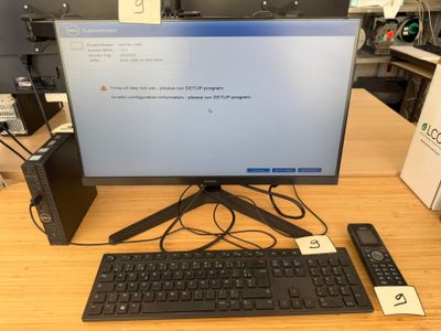 a computer monitor and keyboard on a desk with a remote