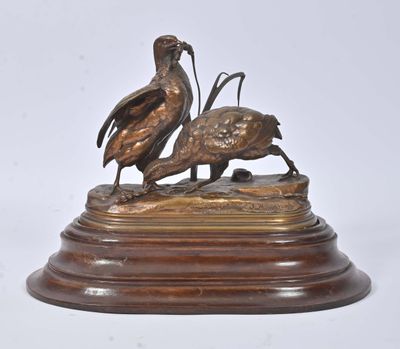 sculpture en bronze représentant deux oiseaux sur un socle en bois, sur fond blanc
