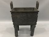 une vieille jardinière en métal posée sur une table blanche
