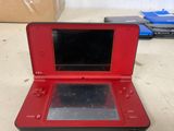 a red nintendo 3ds sitting on a table