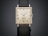 une vieille montre en argent avec un bracelet en cuir noir sur fond noir