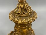 an antique brass candle holder with a bird on top of it