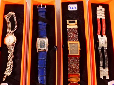 Plusieurs montres se trouvent dans une boîte, chacune étant attachée à une chaîne.