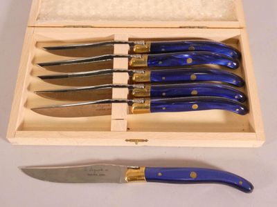 five knives in a wooden box with a blue handle