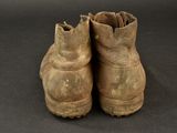 an old pair of brown boots sitting on top of a black surface