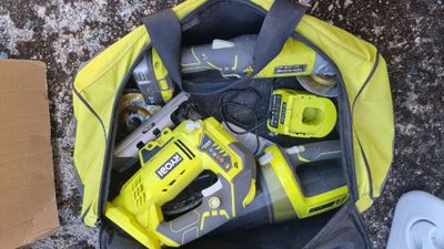 a yellow tool bag with tools in it on the ground