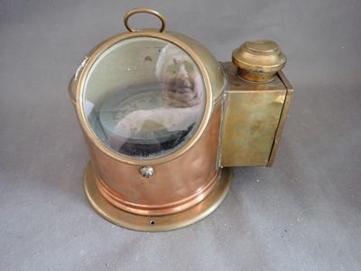 une petite horloge en laiton recouverte d'un couvercle en verre