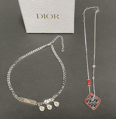 two pieces of jewelry sitting on top of a table next to a box