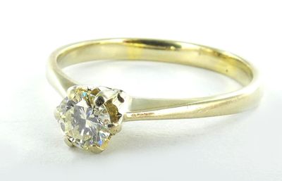 gros plan d'une bague en diamant sur une surface blanche