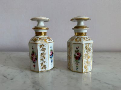 deux vases blancs et dorés posés sur une table en marbre