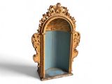 une petite étagère dorée et bleue sur laquelle est posé un miroir