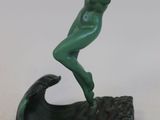 statue d'une femme sur une vague, recouverte d'une patine verte
