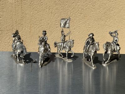 five figurines of people riding horses and holding flags