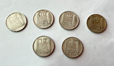 six types de pièces différents posés sur une surface blanche