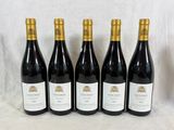 six bouteilles de vin rouge sont alignées sur une table