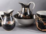 four pieces of black and white vases and bowls on the table