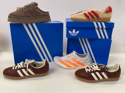 two pairs of shoes that are on top of a box